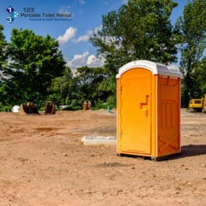 Bright orange portable toilet on a construction site